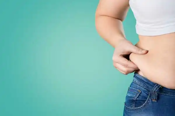 Image of woman pinching her love handles to show weight gain Liberton